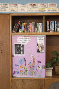 A bookshelf filled with books and artwork.